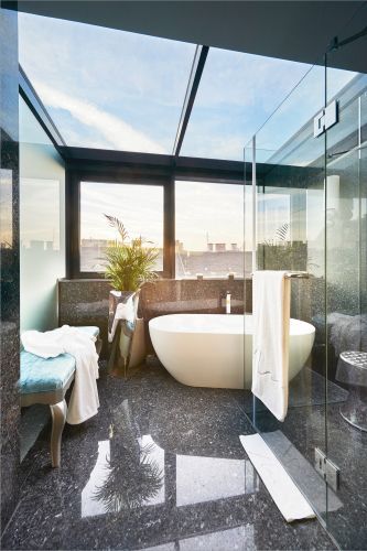 Stunning, sun-filled blue granite bathroom with freestanding soaking bathtub at our Liszt Studio