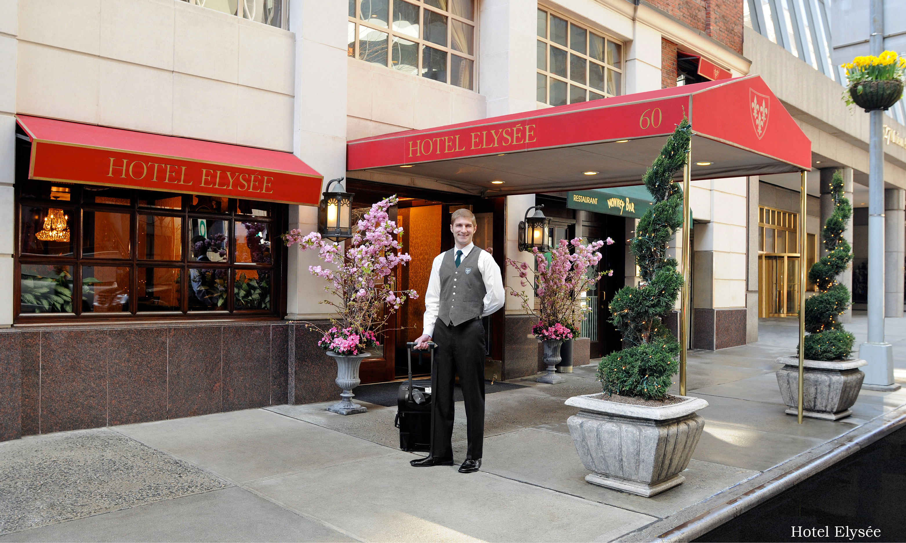 bellman standing outside hotel elysee with luggage